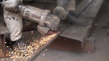 Demir bir borunun kaynaklarını parlatan bir adam.