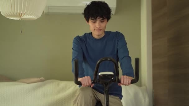 Άντρας Που Χρησιμοποιεί Ποδήλατο Γυμναστικής Στο Σπίτι — Αρχείο Βίντεο