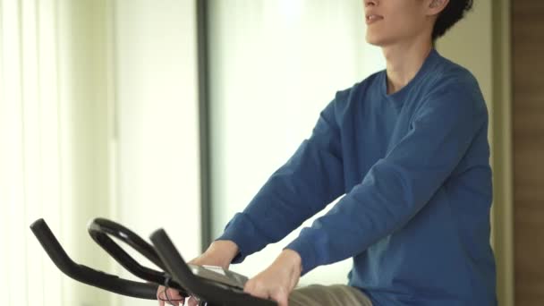 Άντρας Που Χρησιμοποιεί Ποδήλατο Γυμναστικής Στο Σπίτι — Αρχείο Βίντεο