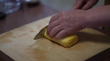 Dashimaki yumurtası kesen bir kadın.