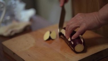 Tatlı patatesleri kesen kadın