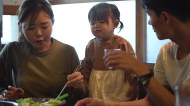 Ailesi ve çocuğu Yakiniku restoranında yemek yiyor.