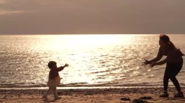 Ebeveyn ve çocuk sahilde oynuyorlar.