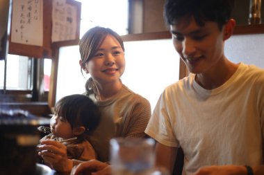 Ailesi ve çocuğu Yakiniku restoranında yemek yiyor.