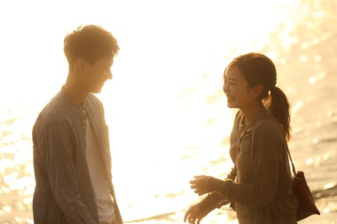 Çift sahilde gülümseyen