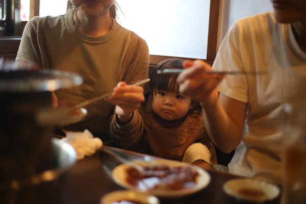 焼肉レストランで食べる親子 — ストック写真