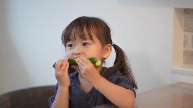 Salatalık yiyen bir kız resmi