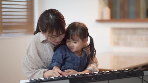 父母和孩子练习弹钢琴 — 图库视频影像