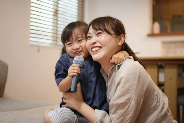 Parent and child enjoying karaoke at home
