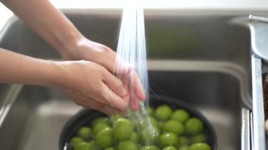 Image of a woman washing plums