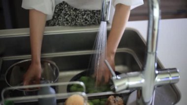 Image of a woman washing plums
