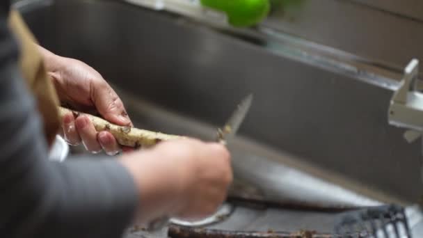 Kobieta Obierająca Łopian Nożem — Wideo stockowe