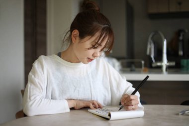 Fırça kalemle yazan bir kadın.