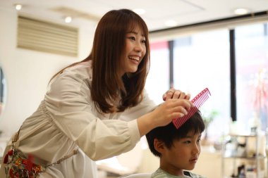 Gülümseyen kuaför ve oğlan