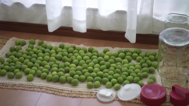 屋内で乾燥する緑のプラムおよびガラスびん — ストック動画