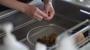 Bir kadın erik şurubundan alınan erik meyvesinden tohum topluyor.