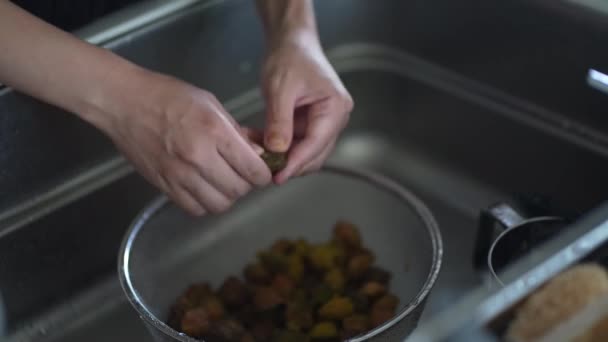 女性はプラムシロップから取られた梅の果実から種を取り除きます — ストック動画