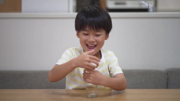 Ένα Αγόρι Που Προσπαθεί Βγάλει Βώλους Από Ένα Μπουκάλι — Αρχείο Βίντεο
