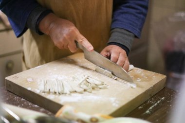 Soba eriştesi kesen bir kadın.