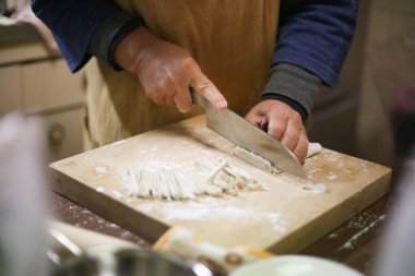 Soba eriştesi kesen bir kadın.