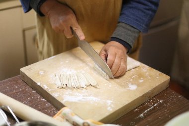 Soba eriştesi kesen bir kadın.