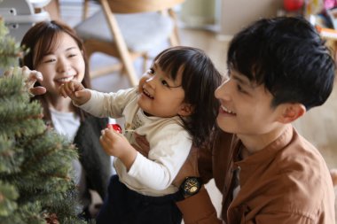 Ebeveynler ve çocuklar Noel ağacı birleştiriyor