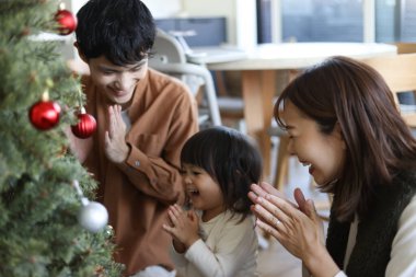 Ebeveynler ve çocuklar Noel ağacı birleştiriyor