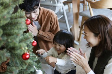 Ebeveynler ve çocuklar Noel ağacı birleştiriyor