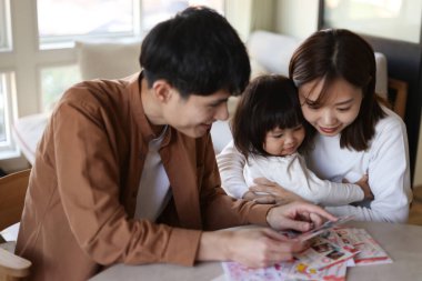 Anne ve baba yeni yıl kartına bakıyor.