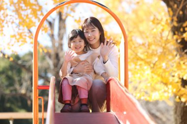 Kaydırakta ebeveynler ve çocuklar oynuyor