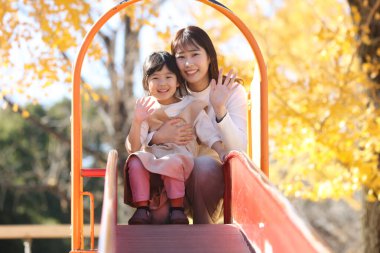 Kaydırakta ebeveynler ve çocuklar oynuyor