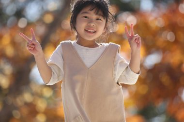 Parkta oynayan gülümseyen kız.