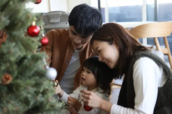 Ebeveynler ve çocuklar Noel ağacı birleştiriyor