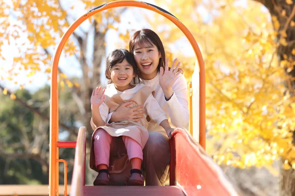 Kaydırakta ebeveynler ve çocuklar oynuyor