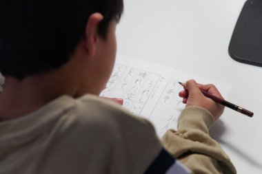 Kaligrafi pratiği yapan bir çocuk.