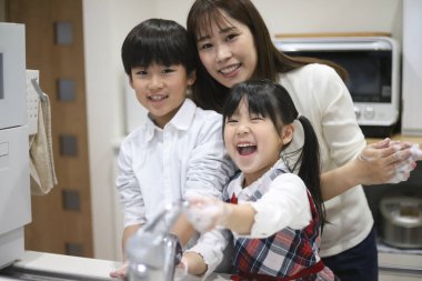 Ebeveyn ve çocuk ellerini yıkıyor.