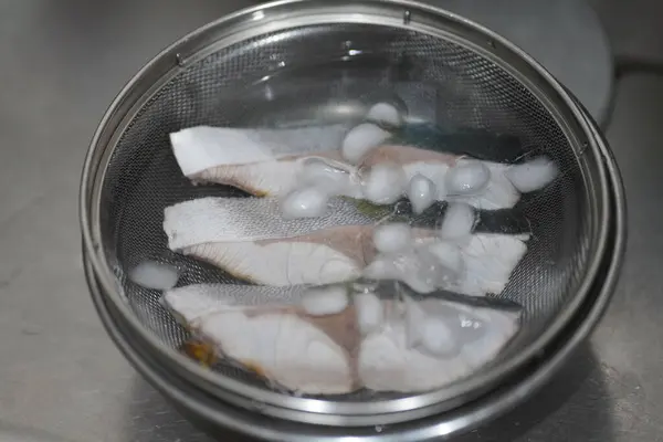 在冰水中冷却煮沸的黄尾鱼 — 图库照片