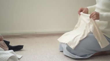 Çamaşır katlayan bir kadın resmi