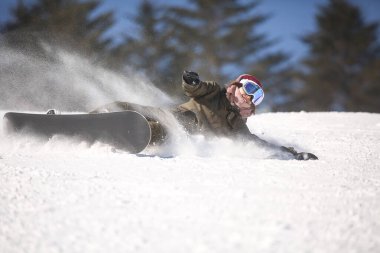 Kadın snowboardcu düşüyor.