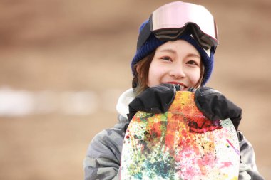 Snowboard kıyafeti giymiş bir kadın resmi