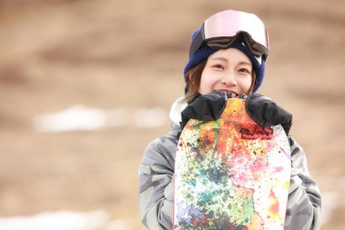 Snowboard kıyafeti giymiş bir kadın resmi