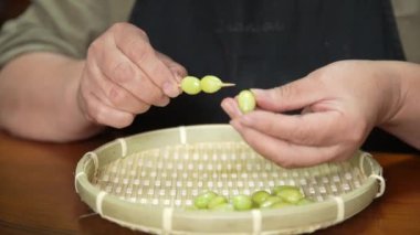 Kürdana ginkgo koyan bir kadın.