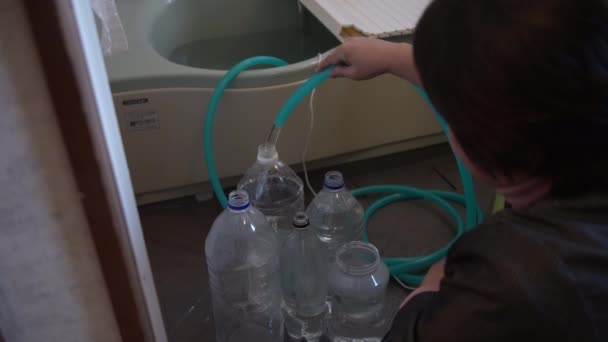 Een Vrouw Die Badwater Verzamelt Een Plastic Fles — Stockvideo