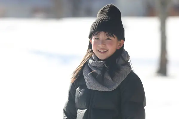 Stock image Smiling girl standing on a snowy field