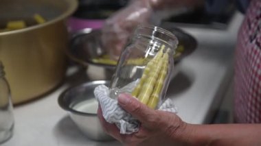 Yozlaşmış bambu şişeleyen bir kadın.