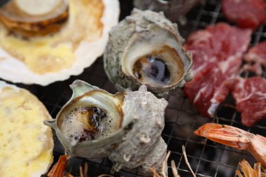 Kömürün üzerinde ızgara yapılmış deniz ürünleri.