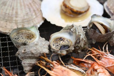 Kömürün üzerinde ızgara yapılmış deniz ürünleri.