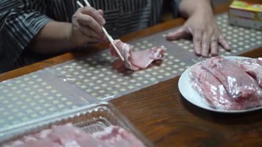 Domuz eti ayıran ve depolayan bir kadın.