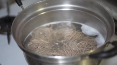 Soba şehriyelerinin nasıl kaynatıldığının resmi.