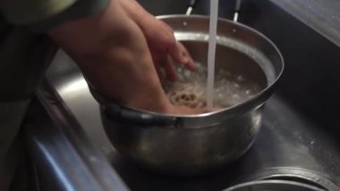 Haşlanmış soba eriştesini durulayan bir kadın.